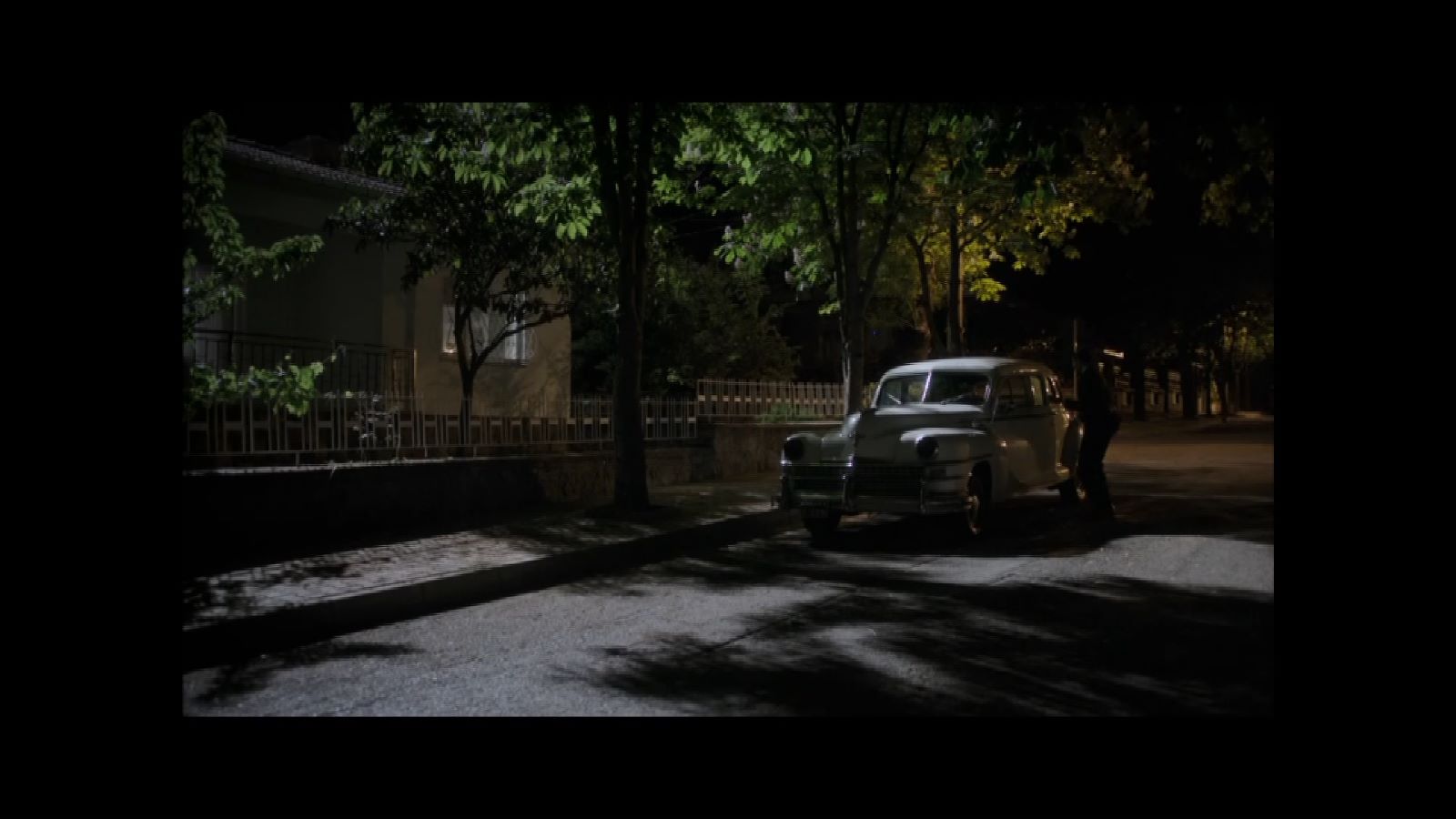 Ben Onu Çok Sevdim — A vintage car on a tree-lined street at night.
