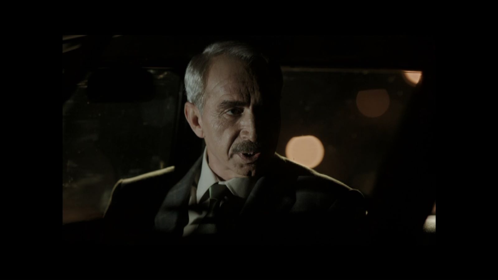 Ben Onu Çok Sevdim — A man in military uniform seated inside a dimly lit car.
