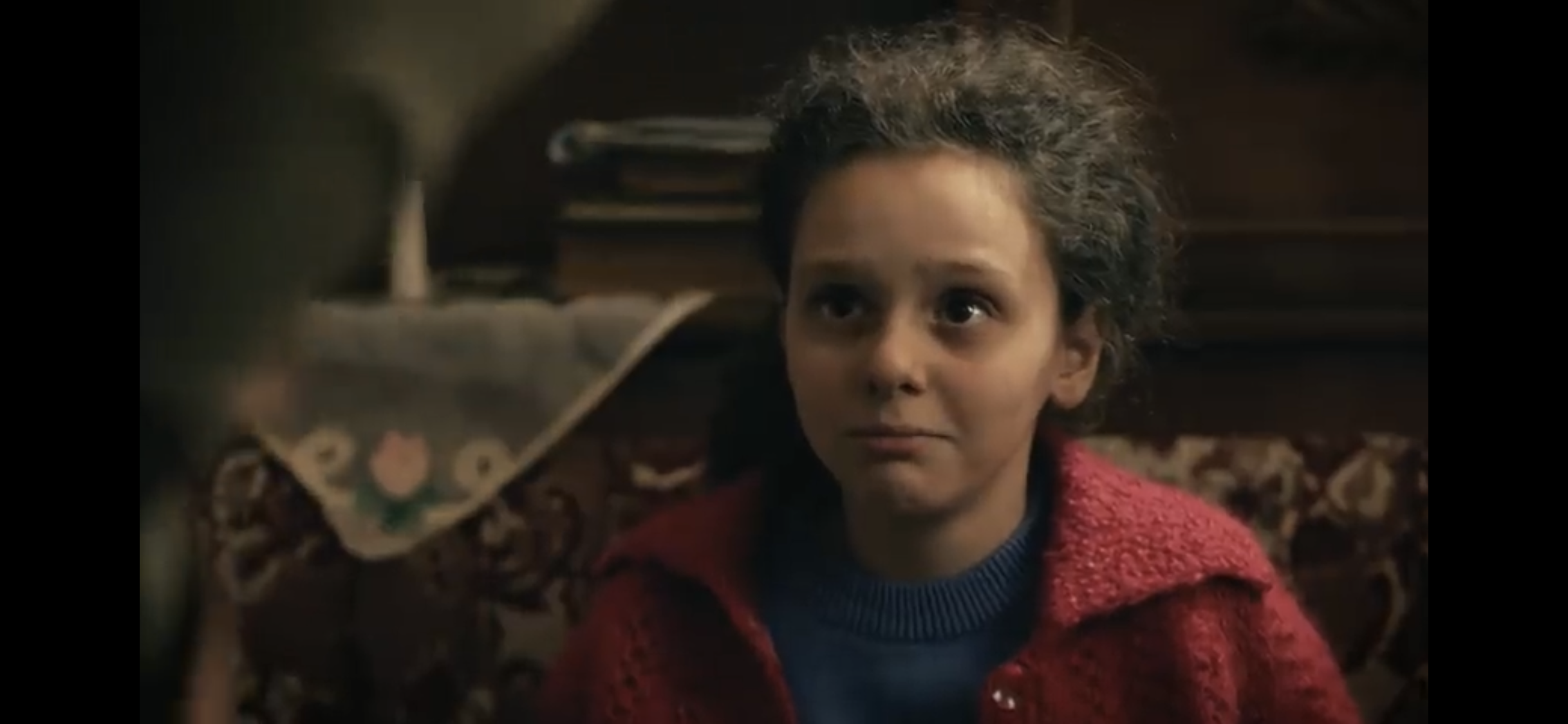 Bir Deli Sevda — A girl in a red coat seated indoors.