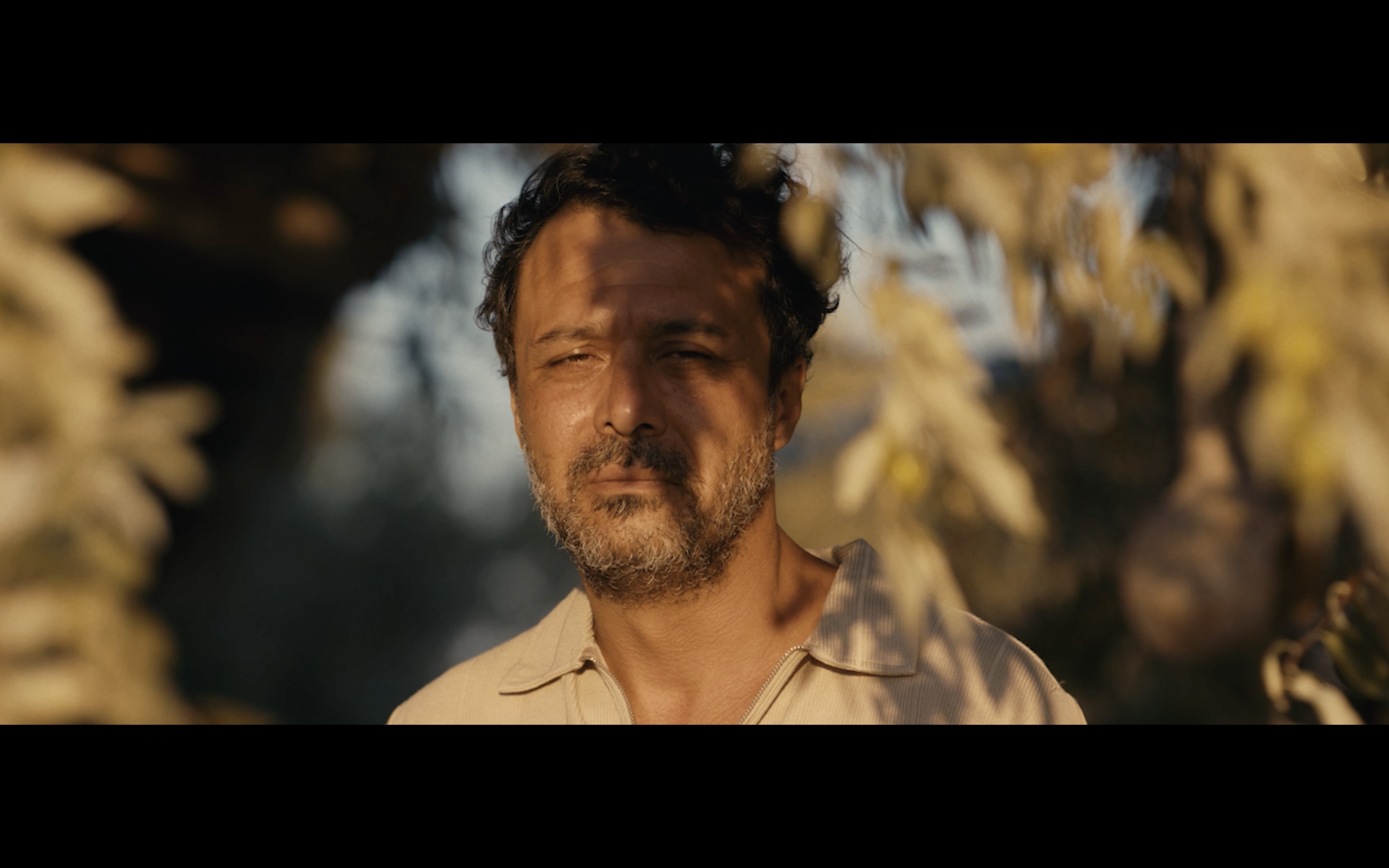 Kavanoz — A man standing outdoors in warm sunlight.
