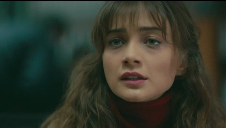 Masum Değiliz — Close-up of a woman with bangs against a softly blurred background.