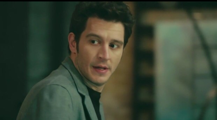 Masum Değiliz — A man turning toward someone beside him indoors.