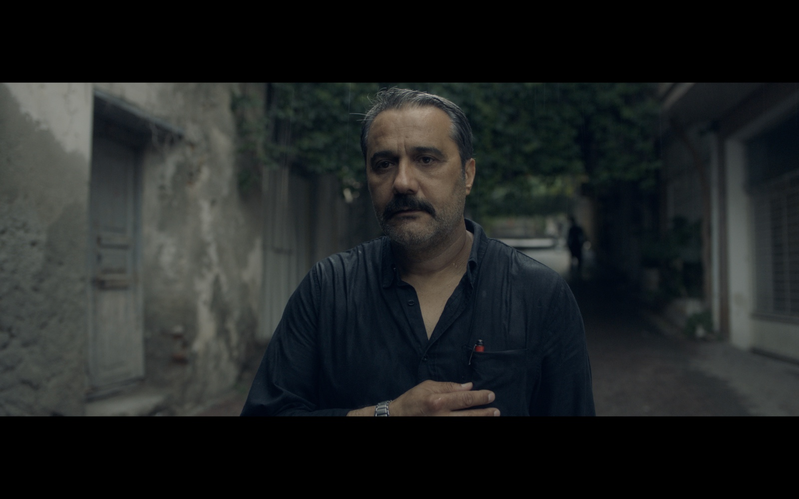 Radyo Günleri — A man standing in a narrow street.