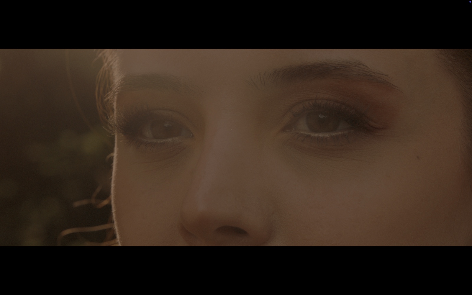 Radyo Günleri — Close-up of a woman’s eyes in warm light.